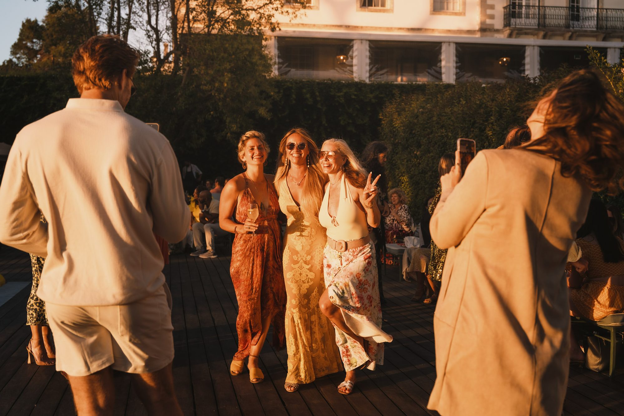 Three friends laughing together in golden evening light