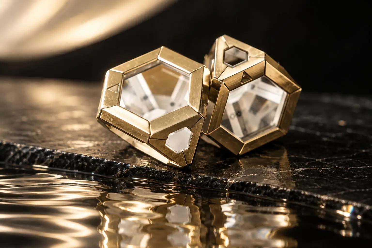 Two gold ARQ cages on black glass, reflected
