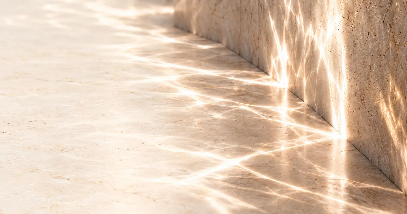 Sunlight rippling across a travertine wall and floor